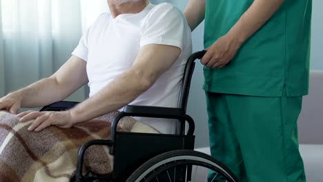 Aged-man-sitting-in-wheelchair-at-nursing-home,-feeling-lonely-and-forgotten