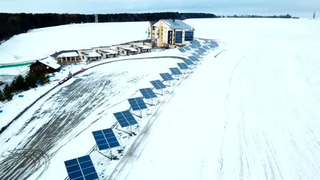 Freizeitzentrum-mit-Sonnenkollektoren-bedeckt-mit-Schnee-am-Rande-der-Stadt.