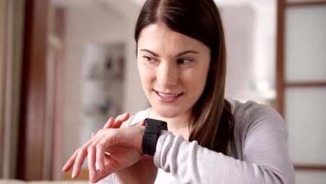 Woman-at-home-sending-audio-message-via-smart-watch.-Young-female-professional-working-on-smartwatch