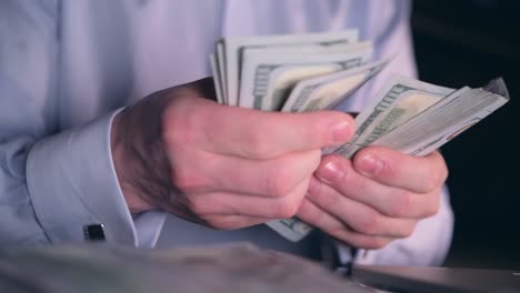 Banknotes-Counting-Closeup-Photo.-Caucasian-Man-Counting-His-Hard-Earned-Money.-One-Hundred-Dollars-Bills.