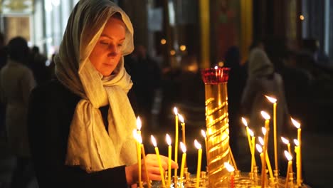 Frau-zündet-die-Kerze-in-der-russisch-orthodoxen-Kirche.