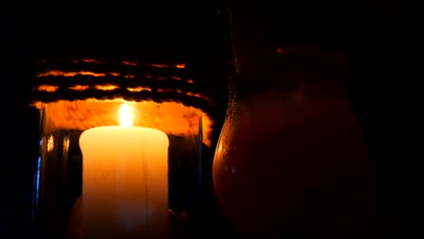 Candle-in-a-restaurant-on-a-black-background-in-a-candlestick-near-the-cocktail,-on-the-beach