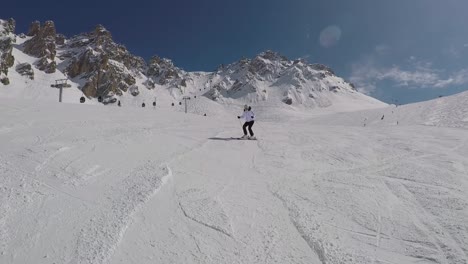 Active-Mature-Skier-Skiing-Down-From-The-Mountain-Slopes-In-Winter-On-Alpine-Ski