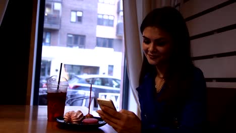 Young-charming-woman-drinks-a-refreshing-drink-sitting-in-a-cafe.