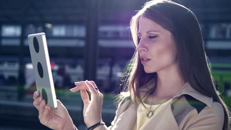 Good-looking-young-female-working-on-digital-tablet-in-public-space-outside