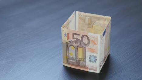 Moneda-de-la-Unión-Europea-invirtiendo-en-metáfora-inmobiliaria-4K-2160P-30fps-UHD-video-casa-en-forma-de-50-euros-concepto-de-dinero-en-billetes-de-euro-4K-3840X2160-imágenes-UltraHD