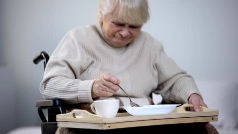 Señora-con-discapacidad-a-regañadientes-cenando-en-centro-médico,-cuidado-inadecuado