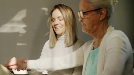 Mujer-joven-enseñando-abuela-a-usar-Tablet