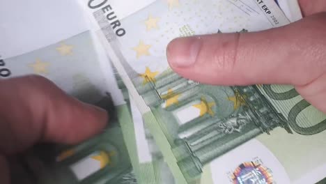 Man-Counting-100-Euro-Banknotes