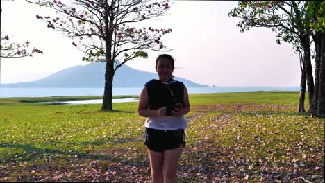 An-Asian-woman-jogging-in-natural-sunlight-in-the-evening-and-listening-to-music.-She-is-trying-to-lose-weight-with-exercise.--concept-health-with-exercise.