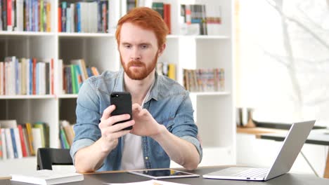 Gelegenheits-Redhead-Mann-mit-Internet-auf-Smartphone