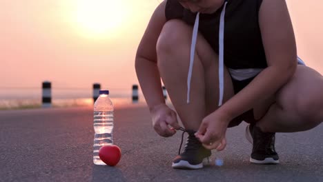 Healthy-start-With-Exercise.-woman-tying-shoe-laces-in-the-early-morning-sunlight-Prepare-for-exercise-for-health