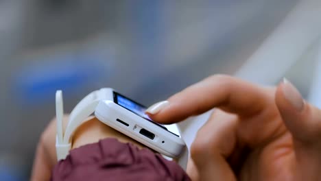 Woman-using-white-smart-watch-on-subway-platform