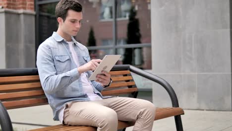 Gelegenheits-Junal-Mann-Sitting-Outdoor-und-Using-Tablet