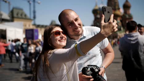 Pareja-joven-tomando-auto-retrato-selfie-foto-en-la-plaza-roja-en-Moscú.