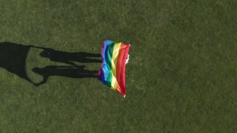 Drohnenaufnahme-von-lgbt-Flagge-flattert-in-weiblichen-Händen