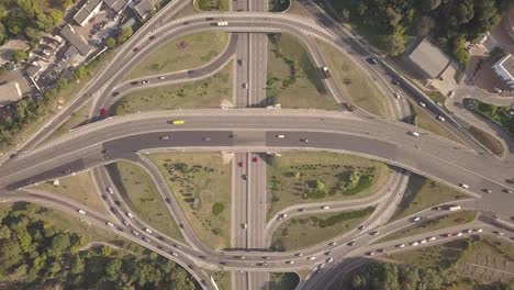 Aerial-high-drone-in-4K-flight-over-evening-road-traffic-in-Kiev,-Ukraine.-Highway-and-overpass-with-cars-and-trucks,-interchange,-two-level-road-junction-in-the-big-city.-Top-view.