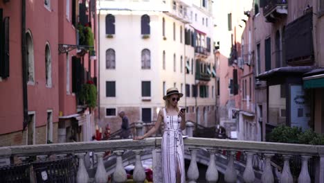 Slow-motion-effect-of-young-hipster-girl-in-sunglasses-resting-on-italian-bridge-and-watching-effect-online-on-content-web-page