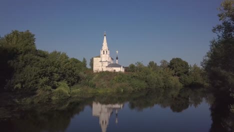 Flug-über-den-Fluss-und-schöne-Kirche-in-Susdal.-Russland.-Luftaufnahme-von-Drohne