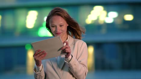 Businesswoman-using-electronic-tab-outdoors-in-the-evening