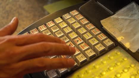 Man-typing-number-into-the-cash-register-for-checkout