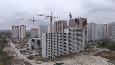 4k-Vista-aérea-grandes-grúas-de-construcción-y-casas-inacabadas