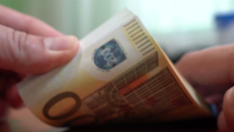 Fingers-sorting-through-a-stack-of-banknotes.-A-stack-of-notes-for-200-euros.-Close-up.-Counterfeit-money.