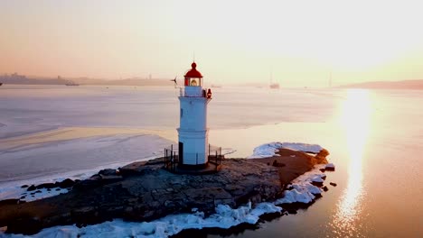 Aerial-winter-view-of-the-Tokarevskiy-lighthouse---one-of-the-oldest-lighthouses-in-the-Far-East,-still-an-important-navigational-structure-and-popular-attractions-of-Vladivostok-city,-Russia.