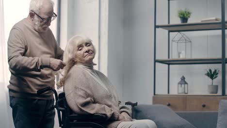 Senior-man-calming-down-woman-with-dementia-in-wheelchair