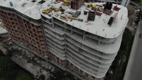 Aerial-shot-of-building-residential-house.-Construction-tower-crain-standing-next-to-house.-4K