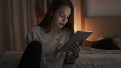 Teen-Mädchen-mit-digitalen-Tablet-spät-eabendim-Schlafzimmer