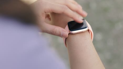 Close-up-athlete-checking-fitness-progress-on-her-smart-watch-after-running-workout.