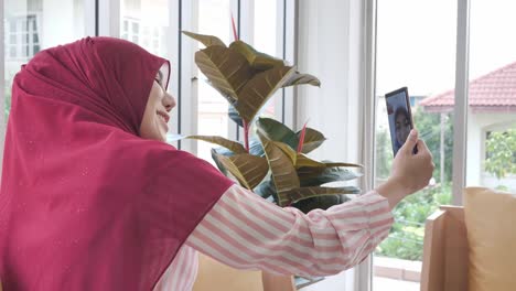 Happy-muslim-woman-using-smartphone-for-video-call-in-home.