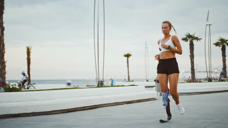 Behinderte-Läuferin-überprüft-ihre-Aktivität-auf-Smartwatch-während-des-Lauftrainings-im-Freien,-Zeitlupe