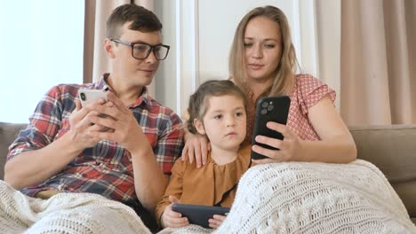 Familie-von-Mutter-Vater-und-Tochter-verwenden-verschiedene-Gadgets