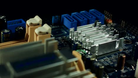 components-of-the-motherboard-are-spinning-on-a-black-background,-sata-slots-and-RAM