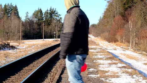 Mann-mit-einer-roten-herzförmigen-Ballon-nahe-dem-Bahnhof