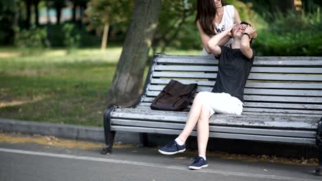 Schöne-Lesben-treffen-im-grünen-Park-auf-Bank