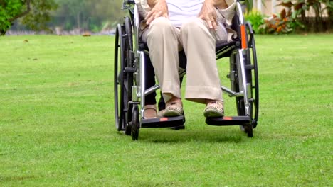 Elderly-woman-relax-on-wheelchair-in-backyard-with-daughter