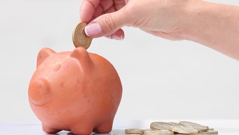 Frau-in-einer-traditionellen-Ton-Piggy-Bank-Geld-sparen