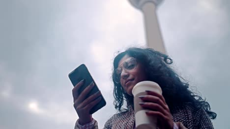 Mujer-hermosa-de-raza-mixta-con-teléfono-inteligente-tecnología-aplicación-vida-feliz-estilo-de-vida-urbano-en-el-fondo-de-la-torre-de-televisión-de-Berlín