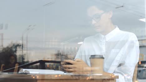 Woman-using-phone-at-cafe