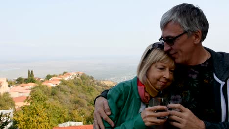 Happy,-smiling-mature-couple-drinking-wine-outdoors.-Hugs,-happy-long-life