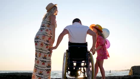 Family-with-child-woman-with-disabled-husband-and-kid-hugging-each-other