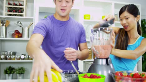 Happy-Asian-Chinese-couple-making-organic-fruit-drink