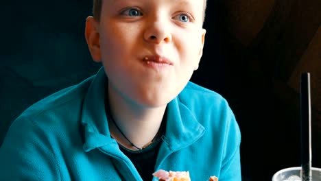 Mouth-of-a-teenager.-The-boy-with-an-appetite-eats-big-hamburger-in-a-fast-food-restaurant