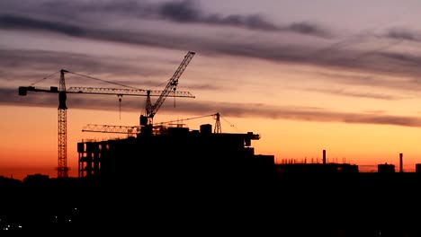 Construction-of-high-rise-building-against-on-the-background-of-sunrise,-time-lapse