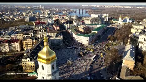 A-bird's-eye-view,-panoramic-video-from-the-drone-in-FullHD-to-the-Saint-Sophia's-Cathedral,-Sofiyivska-Square,-left-bank-of-city-in-the-city-of-Kiev,-Ukraine.-People-on-the-square-on-Easter-days.