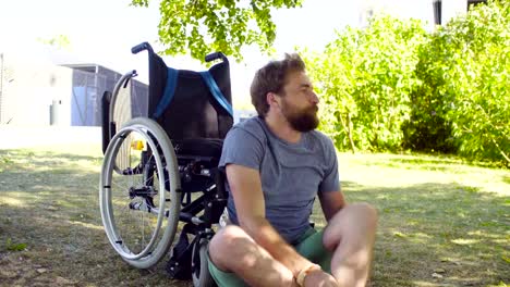 Young-disable-man-trying-to-sit-down-in-a-wheelchair