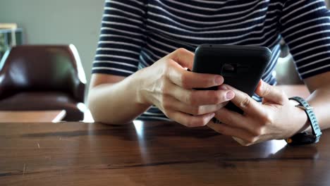 Woman-hand-using-smartphone-in-cafe-shop-background.-Business-and-social-network-concept.